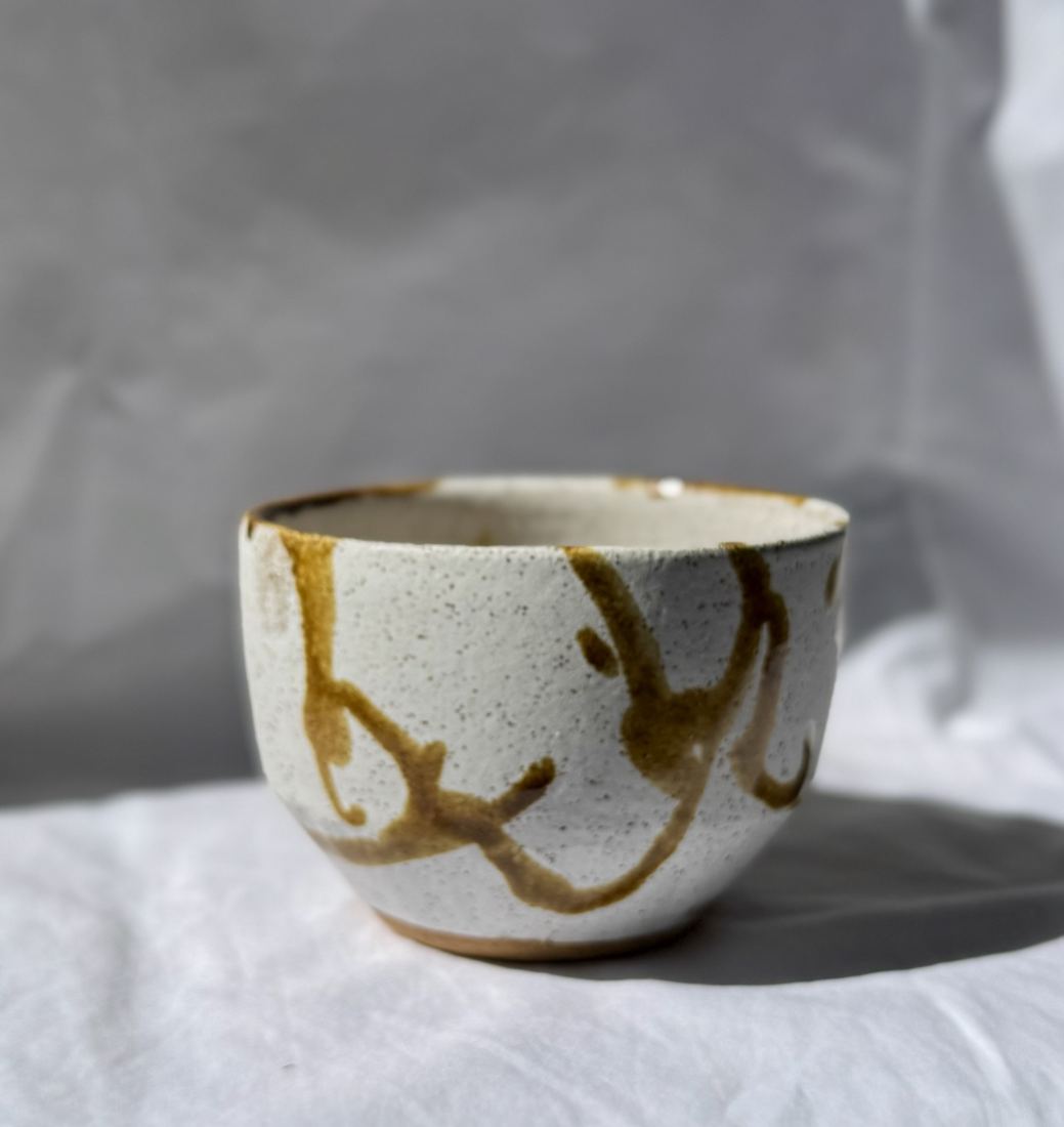 Speckled white tea bowl with amber brushwork