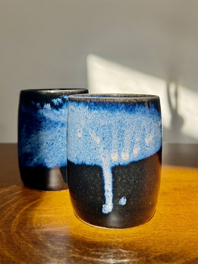Two tumblers with blue glaze dripping over black